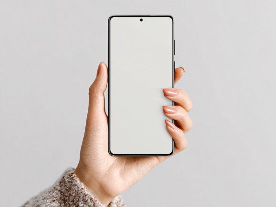 Kobieca dłoń trzyma telefon, na którym będzie wyszukiwać aplikacje do sprzątania.