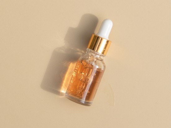 Serum do twarzy z kawasami PHA leży na beżowym tle.