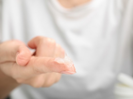 Wyciągnięta dłoń z nałożoną wazeliną na palce