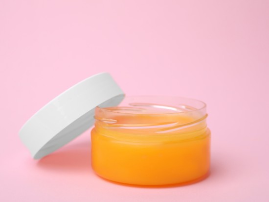 Słoik z wazeliną do skóry na różowym tle