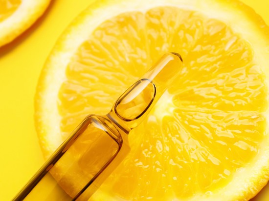 Ampułka z witaminą c na plastrze pomarańczy
