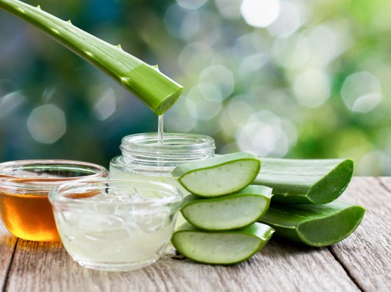 Wyciskanie soku z liścia aloesu do szklanego naczynia.