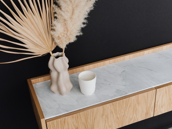 Minimaliztyczna szafka na drobne przedmioty udekorowana suszkami.