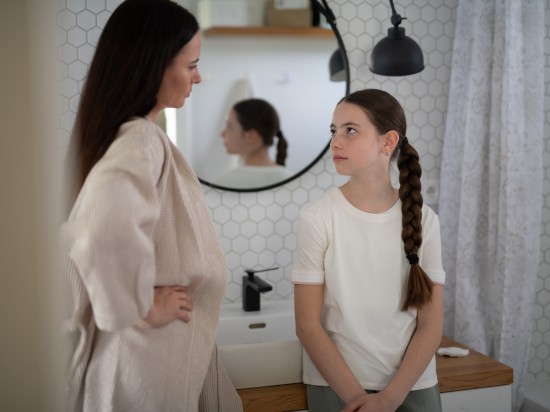 Mama z córką rozmawiają w łazience o pielęgnacji skóry