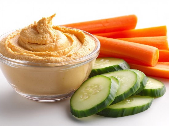 Na zdjęciu widac zdrowe przekąski do pracy i szkoły: humus, ogórek i marchewka.