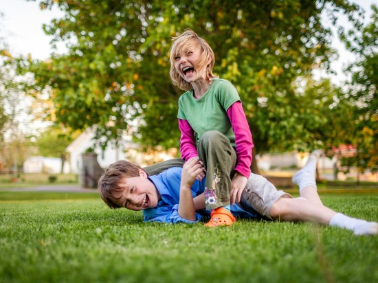 Zdrowe i wesołe dzieci bawią się razem ze sobą na świeżym powietrzu w parku.